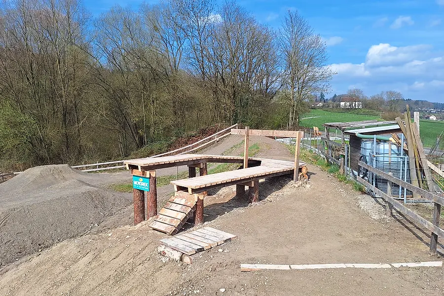 Fertig modellierte Kieswälle und die neu gebauten hölzernen Drops, dahinter die Felder von Merenschwand.